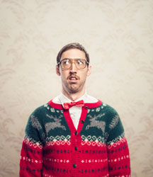 Man with glasses wearing brightly colored Christmas sweater and bow tie