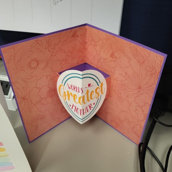 Print-then-cut image created with registration marks and glued in the middle of the pop-up fold of the card. Floral cardstock cut with Silhouette Pop-Up card feature and glued to external card cut from purple card stock.