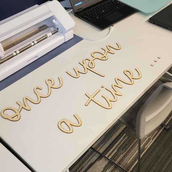 The words once upon a time... in a script font cut out of birch word.