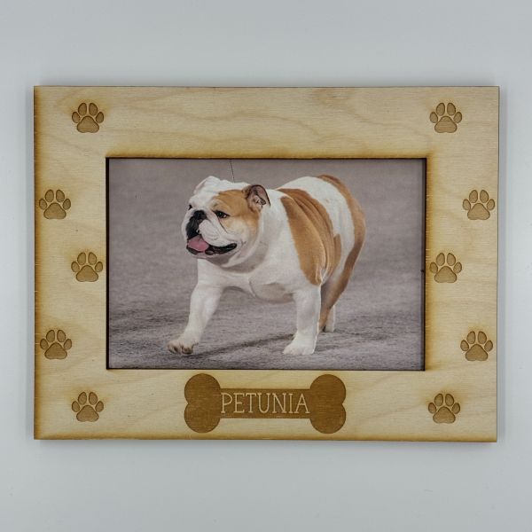 Rectangle picture frame etched with with paw prints on the right and left sides, and a bone in the middle bottom with a name on it that says Petunia.