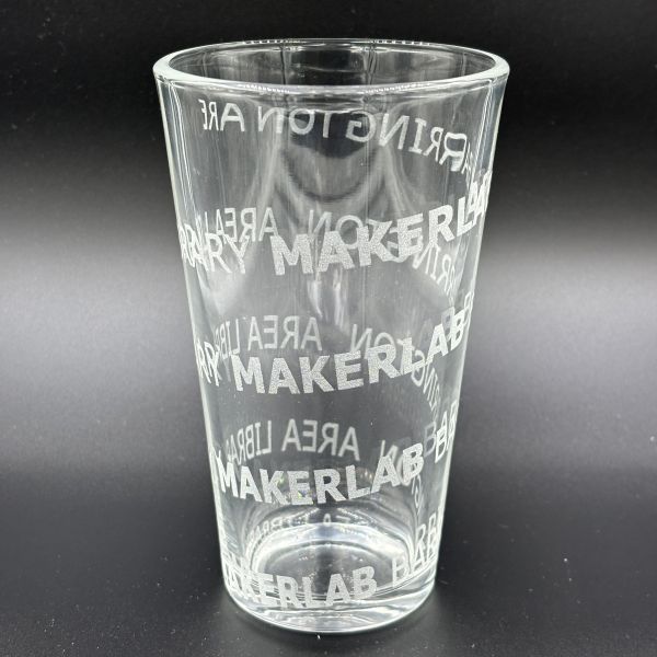 Spiral design that says Barrington Area Library MAKERLAB etched all the way around a pint glass.